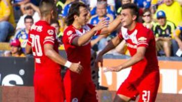 Enrique Triverio celebra con sus compañeros su primer gol en la Liga MX.