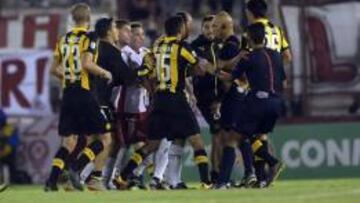 Varios jugadores de Huracán y Peñarol reclaman al árbitro.