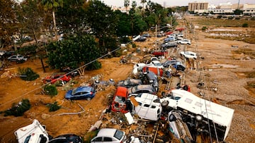 Los vehículos se amontonan en las vías del tren después de las fuertes lluvias en Alfafar, en Valencia.