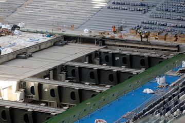 Operarios relizan diversas tareas en la instalación de butacas, vallas de vidrio y pantallas, así como cambios en la instalación de las bandejas del césped.