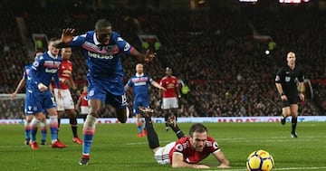 Juan Mata cae mientras pugna por un balón dentro del área con Bruno Martins Indi.