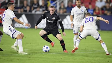 D.C. United forward Wayne Rooney (9) dribbles the ball against Orlando City midfielder Oriol Rosell (20) and defender Shane O'Neill, left, during the first half of an MLS soccer match, Sunday, Aug. 12, 2018, in Washington. (AP Photo/Nick Wass)