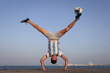 El freestyler Charlie Iacono no ha querido perderse la cita mundialista para apoyar a la selección albiceleste durante su adnadura en Qatar. En la fotografía, el dos veces campeón del mundo de fútbol freestyle muestra sus increíbles habilidades con el balón mientras hace equilibrios cabeza abajo, con la ciudad de Doha al fondo.