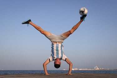 El freestyler Charlie Iacono no ha querido perderse la cita mundialista para apoyar a la selección albiceleste durante su adnadura en Qatar. En la fotografía, el dos veces campeón del mundo de fútbol freestyle muestra sus increíbles habilidades con el balón mientras hace equilibrios cabeza abajo, con la ciudad de Doha al fondo.