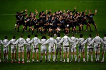 El equipo de los Harlequins observa con los brazos entrelazados la Haka tradicional de los All Blacks antes de un partido. Cada uno hacen grupo a su manera.