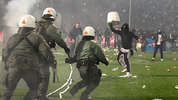 PAOK fans clash with riot police during a Greek Cup semifinal match between PAOK and champion Olympiakos at the Toumba stadium in the northern Greek city of Thessaloniki,