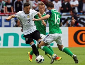 Mesut Ozil entre Steven Davis y Oliver Norwood.