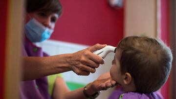 GRAF8269. OURENSE, 01/09/2020.- Una educadora abraza a una niña en el interior de una escuela infantil en Ourense, Galicia, este martes. Escuelas infantiles privadas, casas nido y ludotecas están de regreso este primero de septiembre, al ser los primeros en retomar la enseñanza presencial con las restricciones a las que obliga la pandemia, pues los centros adheridos a la red pública esperarán para hacerlo al próximo día 4. EFE/ Brais Lorenzo