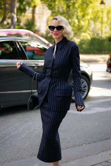 omi Watts luce gafas de sol Fendi, chaqueta de raya diplomática y falda midi a juego, bolso de cuero negro Mugler y tacones negros en la entrada de Mugler durante la Semana de la Moda de París, el 2 de octubre de 2025, en París, Francia.