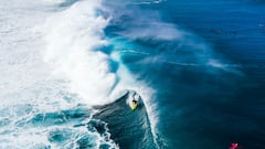 El surfista hawaiano John John Florence surfeando una ola de izquierdas en forma de tubo en Haw&aacute;i (Estados Unidos) durante la Vans Triple Crown of Surfing 2020. Visto desde el aire. Con tabla de surf amarilla.