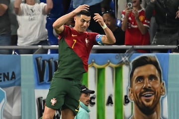 El delantero portugués, Cistiano Ronaldo, hace su característica celebración delante de una pancarta con la cara de Lionel Messi.