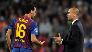Barcelona's coach Josep Guardiola (R) talks with Barcelona's midfielder Sergio Busquets (L) during the Champions League football match between FC Barcelona and Viktoria Plzen at the Camp Nou stadium in Barcelona on October 19, 2011. AFP PHOTO/LLUIS GENE