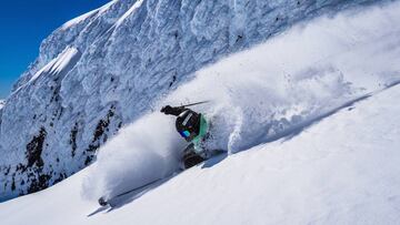 El freerider aranés Aymar Navarro descendiendo por una ladera de Los Andes con una montaña de hielo detrás y levantando nieve polvo durante la última edición del proyecto South Lines.