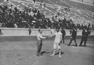 El Carl Schuhmann (vencedor en salto de potro) y el griego Georgios Tsitas se saludan antes de la prueba final de lucha. La prueba tuvo que ser suspendida por falta de luz después de 40 minutos. Se reanudó al día siguiente, y Schuhmann sólo necesitó 15 minutos para acabarla.