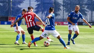 Ricard, del Atl&eacute;tico B, rodeado de jugadores del Melilla.