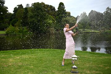 Aryna Sabalenka abriendo una botella de champ¨¢n agitada durante la sesi¨®n de fotos como campeona del Abierto de Australia en los Jardines Reales de Melbourne.