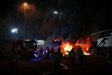 Los bomberos apagan el fuego en un local de venta de merchandising antes del partido entre el Manchester City y el Brujas.