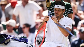 Taylor Fritz cambia el grip de una raqueta durante su partido contra Karen Khachanov en Wimbledon.