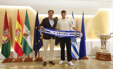 Loren Juarros e Izan Merino posan con una bufanda del Málaga CF tras firmar la renovación del futbolista.