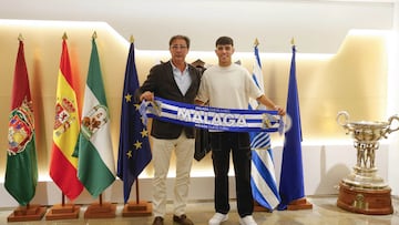 Loren Juarros e Izan Merino posan con una bufanda del Málaga CF tras firmar la renovación del futbolista.