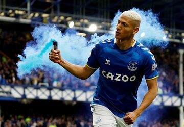 El jugador brasileño del Everton Richarlison celebra su primer gol al Chelsea durante el partido de la Premier League con una bengala azul en la mano. 