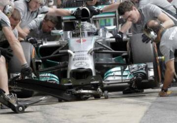 Los mecánicos del piloto alemán, Nico Rosberg, del equipo Mercedes, ensayan el cambio de rueadas.