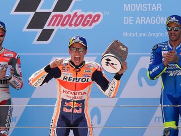 Repsol Honda Team&#039;s Spanish rider Marc Marquez (C) celebrates next to Ducati Team&#039;s Italian rider Andrea Dovizioso (L) and Team SUZUKI ECSTAR&#039;s Italian rider Andrea Iannone (R) on the podium of the MotoGP race of the Moto Grand Prix of Aragon at the Motorland circuit in Alcaniz on September 23, 2018. (Photo by JOSE JORDAN / AFP)