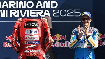 Álex Márquez sonríe en el podio viendo a su hermano mostrar su mono al público de Misano.