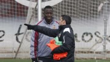 El lateral valencianista, Cissokho, hablando con el t&eacute;cnico Valverde en un entrenamiento de la ciudad deportiva de Paterna.