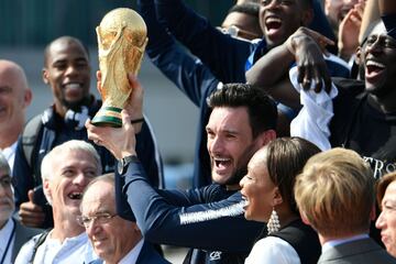France's goalkeeper Hugo Lloris (C) holds the trophy as he celebrates with France's coach Didier Deschamps (L), French Football Federation president Noel Le Graet (2nd L), French Sports Minister Laura Flessel (R) and teammates (back row from L) France's d