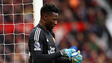 André Onana, jugador del Manchester United, se unta vaselina en los guantes en el partido ante el Liverpool.