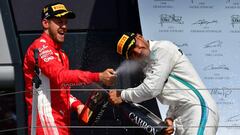 Ferrari&#039;s German driver Sebastian Vettel (L) celebrates winning the British Formula One Grand Prix with second-placed Mercedes&#039; British driver Lewis Hamilton on the podium after the British Formula One Grand Prix at the Silverstone motor racing circuit in Silverstone, central England, on July 8, 2018. / AFP PHOTO / Andrej ISAKOVIC