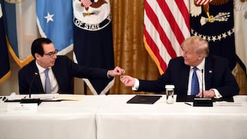 US Treasury Secretary Steve Mnuchin shows US President Donald Trump a pre-paid debit card during a meeting with his cabinet on May 19, 2020 in the Cabinet Room of the White House in Washington, DC. - The card will be issued by the Internal Revenue Service