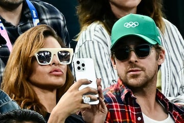 La actriz Eva Mendes y su pareja, el actor canadiense Ryan Gosling atienden desde la grada los ejercicios de barras paralelas de gimnasia artística en el Bercy Arena de París.