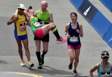 La corredora Julianne Bowe es ayudada para entrar en meta.