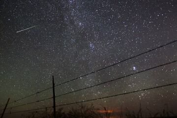 FILE - In this early morning, Aug. 13, 2013 file photo, a meteor streaks past the faint band of the Milky Way galaxy above the Wyoming countryside north of Cheyenne, Wyo., during a Perseids meteor shower. On Thursday night, Aug. 11, 2016 into early Friday morning, the Perseid meteor shower is expected to peak with double the normal number of meteors. Scientists call this an outburst, and they say it could reach up to 200 meteors per hour. (AP Photo/The Wyoming Tribune Eagle, Blaine McCartney)