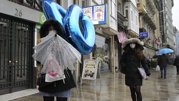 Transe&uacute;ntes caminan protegidos por una v&iacute;a de A Coru&ntilde;a, Galicia (Espa&ntilde;a), a 20 de enero de 2021. El temporal de nieve y posterior fr&iacute;o provocado por la borrasca &#039;Filomena&#039; terminar&aacute; este martes cuando &e