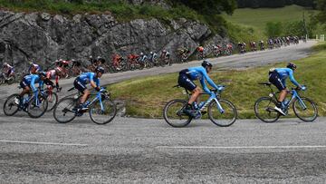 Movistar Team rider Spain's Carlos Verona (R) takes a curve followed by cyclists of the pack during the sixth stage of the 71st edition of the Criterium du Dauphine cycling race, 229 km between Saint-Vulbas Plaine de l'Ain and Saint-Michel-de-Maurienne on June 14, 2019. (Photo by Anne-Christine POUJOULAT / AFP)