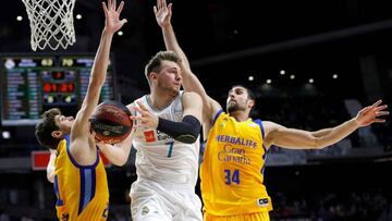 GRAF4204. MADRID, 05/06/2018.- El base esloveno del Real Madrid, Luca Doncic (c), con el balón ante la defensa de los jugadores de Herbalife Gran Canaria, el letón Anzejs Pasecniks (i) y Pablo Aguilar, durante el segundo partido del playoff