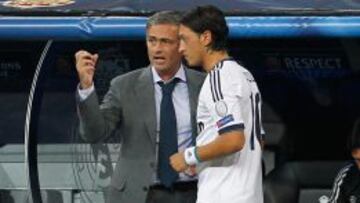 &Oacute;zil dialoga con Mourinho durante un partido del Real Madrid.