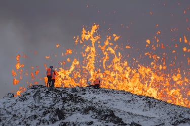 Científicos de la Universidad de Islandia toman medidas y muestras en la cresta frente a la parte activa de la fisura eruptiva del volcán activo en Grindavik. 