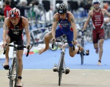 Imagen en la que el francés David Hauss salta a la bicicleta con las botas ya puestas en los pedales para facilitar la transición de la natación al ciclismo durante el campeonato del mundo de triathlon de Londres.