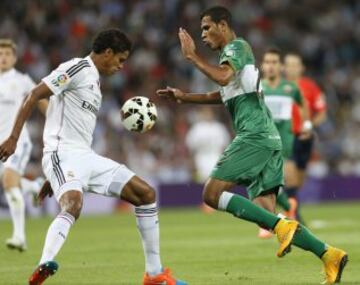 El delantero brasileño del Elche Jonathan de Jesús lucha un balón con el defensa francés del Real Madrid Raphael Varane.