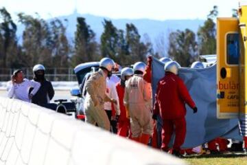 El piloto Fernando Alonso recibe atención tras un accidente durante la cuarta tanda de entrenamientos de pretemporada del Mundial de Fórmula Uno, que se realiza en el Circuito de Cataluña.