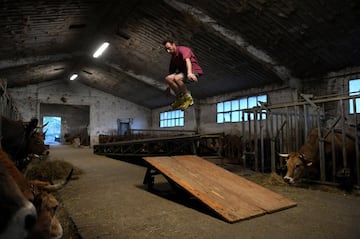 El ganadero Pablo Pato saltando con sus patines en su establo en Llanuces, Asturias.