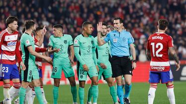 Los jugadores del Atlético hablan con el colegiado del partido ante el Granada.
