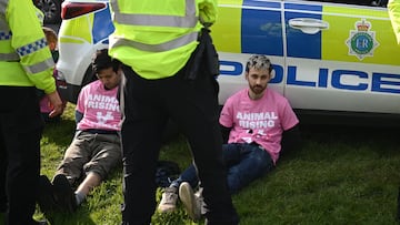 Animal rights protesters are apprehended by police officers ahead of the Grand National Handicap Steeple Chase on the final day of the Grand National Festival horse race meeting at Aintree Racecourse in Liverpool, north-west England, on April 15, 2023. (Photo by Oli SCARFF / AFP)