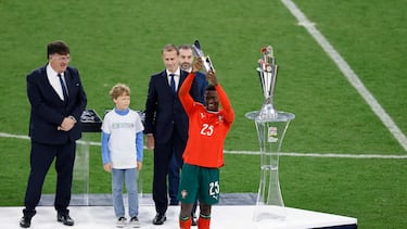 Portugal's defender #25 Nuno Mendes (R) raises the trophy for player of the match after winning the UEFA Nations League final football match between Portugal and Spain in Munich, southern Germany on June 8, 2025. (Photo by Alexandra BEIER / AFP)
