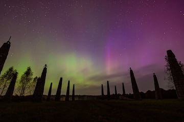 Las luces del norte, también conocidas como auroras boreales, causadas por una fuerte tormenta solar, iluminan el cielo sobre un callejón de objetos de arte que se asemejan a cohetes espaciales en el parque de arte en el pueblo de Nikola-Lenivets, región de Kaluga, Rusia.