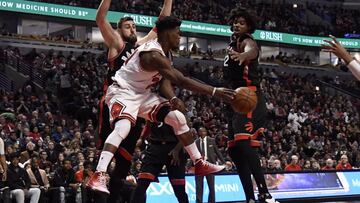 Jan 7, 2017; Chicago, IL, USA; Chicago Bulls forward Jimmy Butler (21) passes the ball around Toronto Raptors center Lucas Nogueira (92) during the second half at  the United Center. The Bulls won 123-118 in overtime. Mandatory Credit: David Banks-USA TODAY Sports